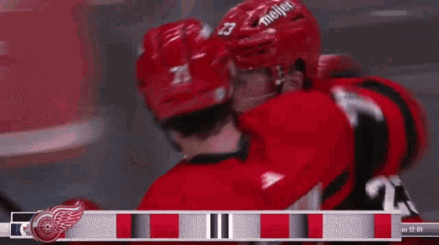 a hockey player with the number 71 on his helmet hugs another player