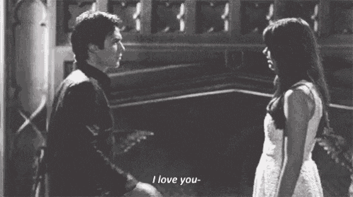a man and a woman are standing next to each other and the woman is saying i love you .