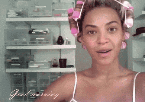 a woman with curlers in her hair says good morning in a closet