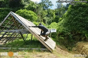 a man is climbing up a wooden wall with the words apache race written on it