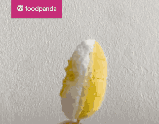 a person is holding a popsicle in front of a foodpanda banner