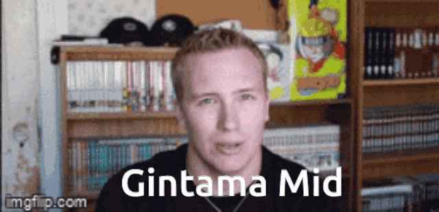 a man is standing in front of a bookshelf with the words gintama mid written on it