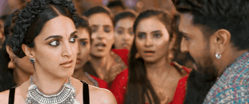 a man and a woman are looking at each other in front of a crowd of people