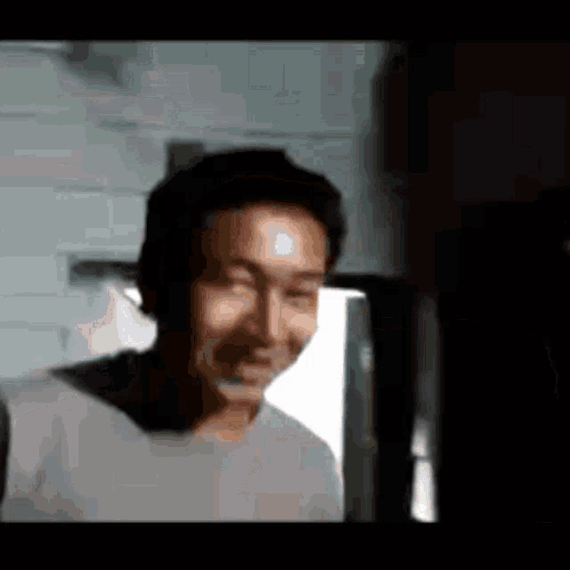 a man wearing headphones is smiling in a blurry photo