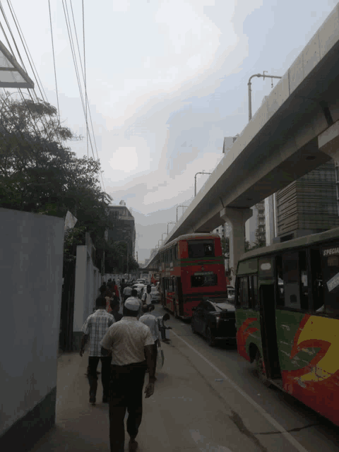 people walking down a street with a red double decker bus that says executive
