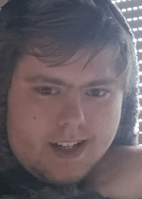 a close up of a man 's face with a hood on