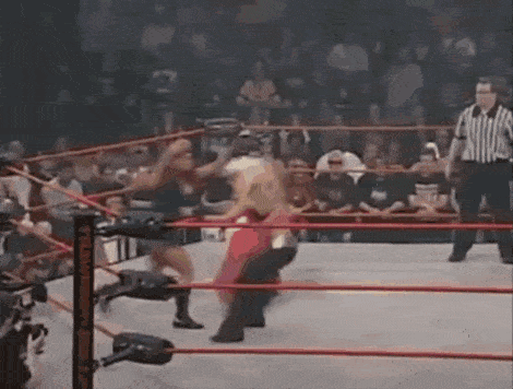 a wrestling match is taking place in a ring with a referee standing in the corner .