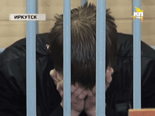 a man in a jail cell with a sign that says irkutsk