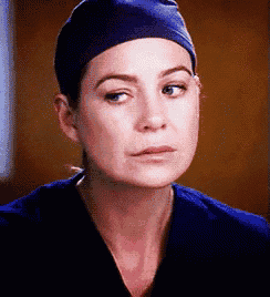a close up of a woman wearing a blue scrub top and a blue hat
