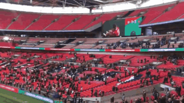 a soccer stadium with empty seats and a scoreboard that says 0-3 on it