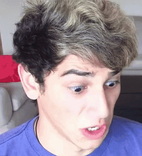 a close up of a young man 's face with a blue shirt on