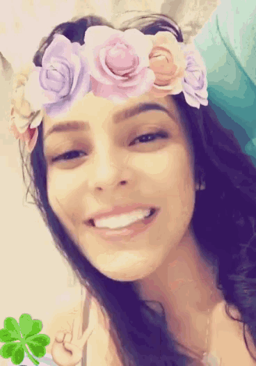 a girl with a flower crown on her head smiles for the camera