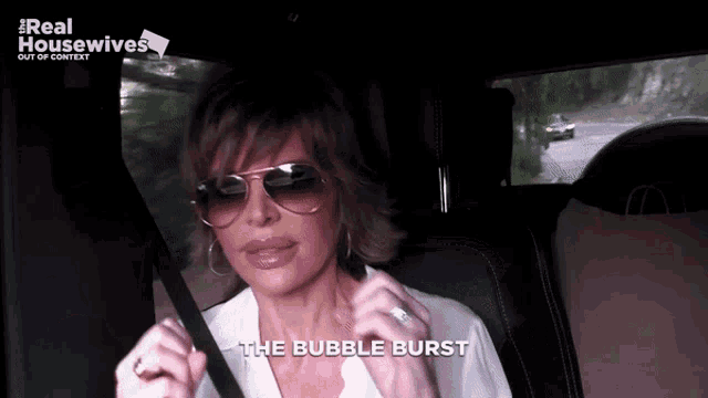 a woman wearing sunglasses is sitting in a car with the words " the bubble burst " on the screen