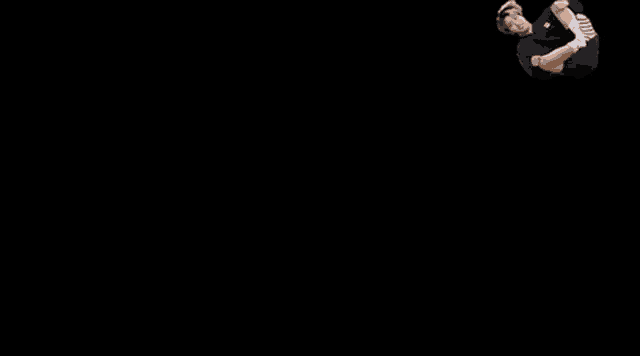 a man is doing a trick on a black background .