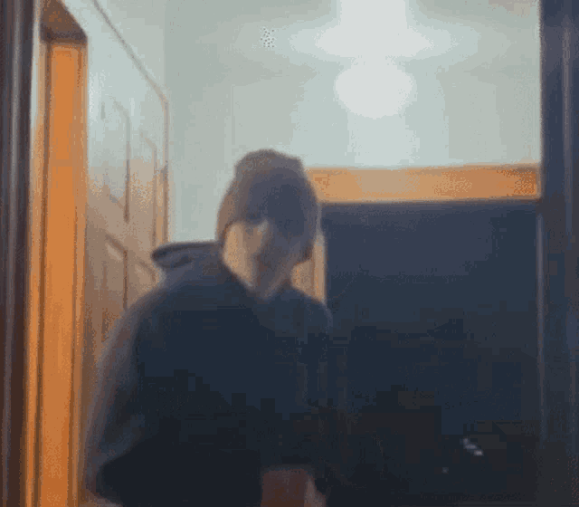 a blurry picture of a woman walking through a hallway