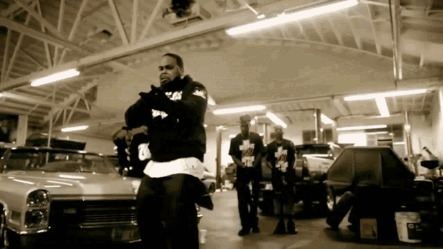 a group of men are standing in a garage with a car that has a license plate that says ' aa ' on it