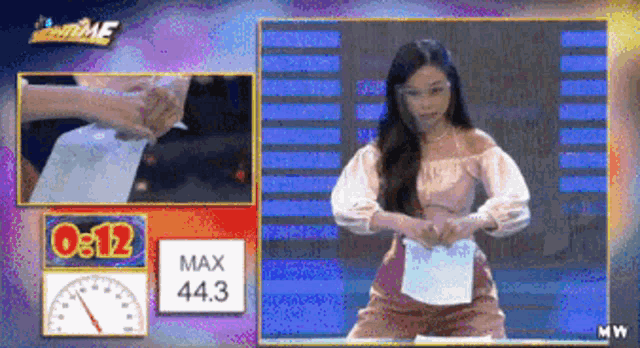 a woman is holding a piece of paper in front of a screen that says 00:12