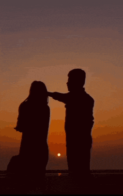a silhouette of a man and a woman making a heart with their hands