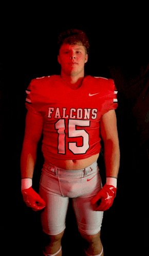 a football player wearing a red jersey that says falcons on it
