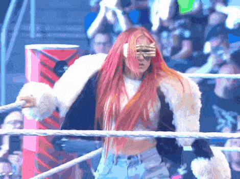 a woman with red hair is standing in a ring wearing sunglasses and a fur coat
