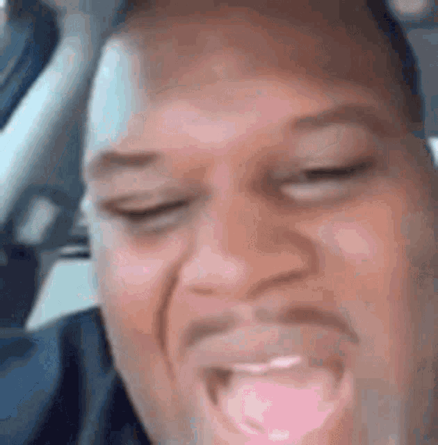 a man with a pacifier in his mouth is making a funny face in a car .