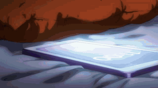 a cell phone laying on a bed with the time 6:07 on the screen