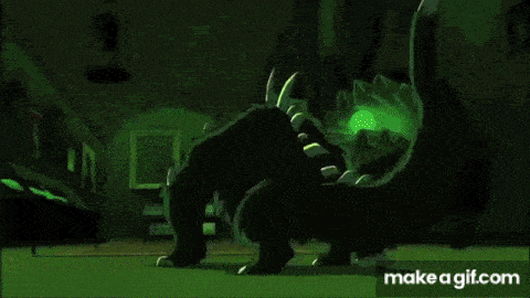 a man in a green shirt is laying on the ground with a monster behind him .