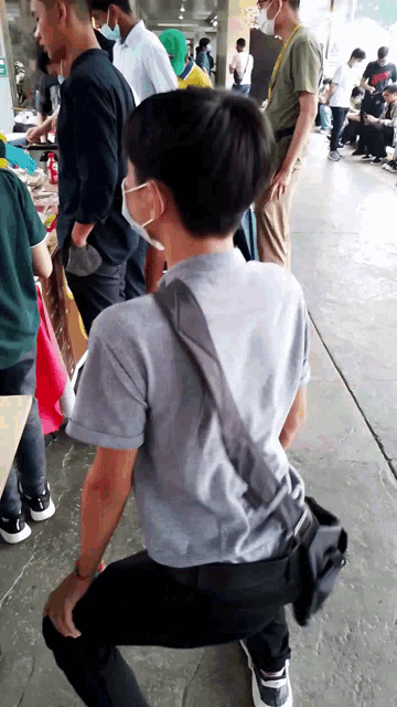 a man wearing a mask kneeling down in front of a crowd
