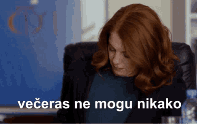 a woman with red hair is sitting in a chair with the words " večeras ne mogu nikako " written on the bottom