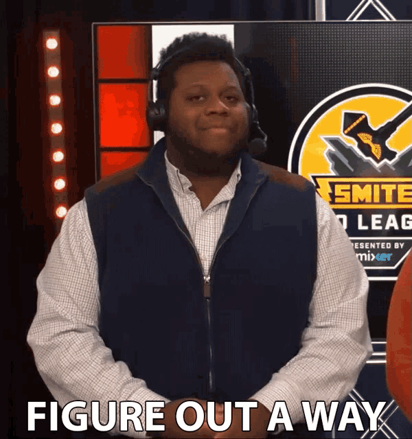 a man wearing headphones stands in front of a smite league sign