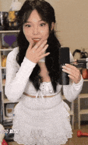 a woman in a white dress is holding a microphone in her hands .