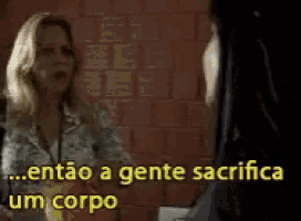 a woman is talking to another woman with the words " entao a gente sacrifica um corpo " behind her