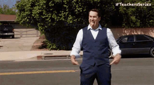 a man in a suit is standing on the side of the road .