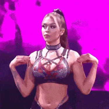 a woman in a crop top with a ponytail is standing in front of a purple background