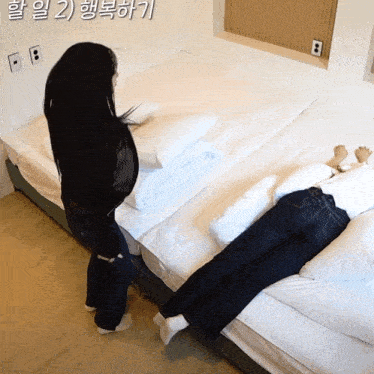 a woman standing next to a bed with a foreign language written on it