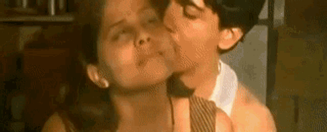 a man is kissing a woman on the cheek .
