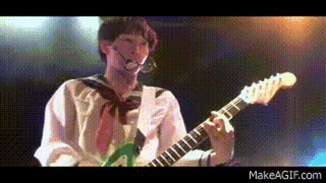 a person is playing a guitar on a stage .