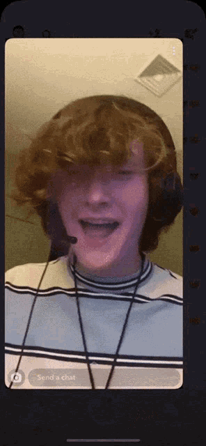 a phone screen shows a man wearing headphones and a microphone with the words send a chat below him