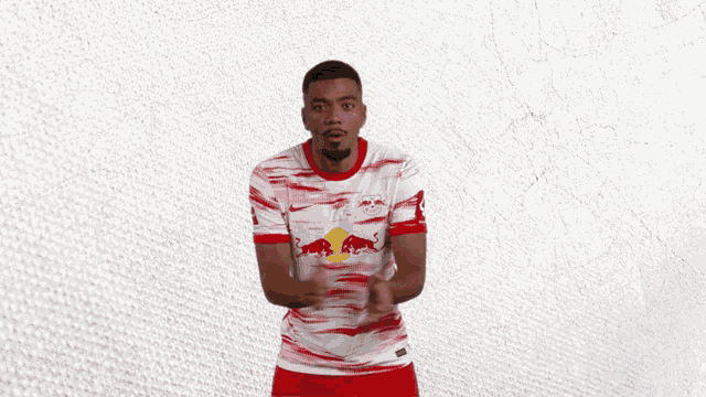 a man in a red and white jersey with a red bull on the front