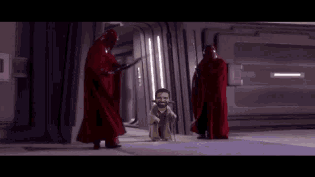 a man with a beard is standing in a hallway next to a red blanket .
