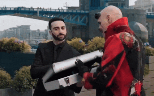 a man in a red jacket is holding a silver briefcase