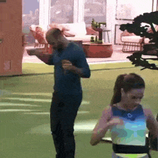 a man and a woman are dancing on a green lawn