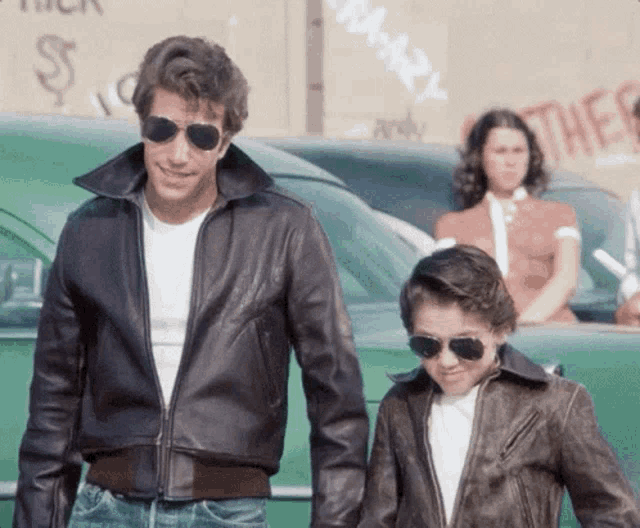 a man and a boy wearing leather jackets and sunglasses