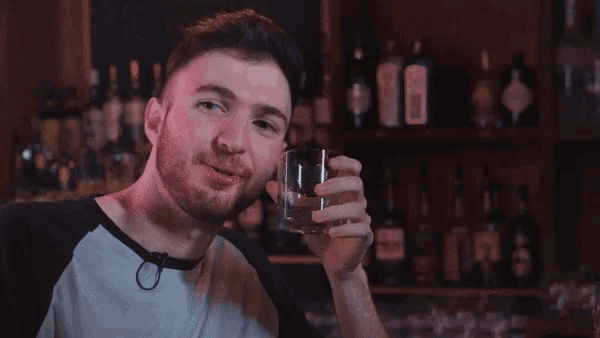 a man is holding a glass in front of a sign that says dolphins