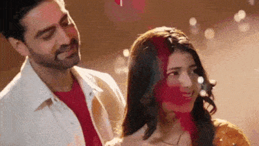 a man and a woman are standing next to each other and smiling .