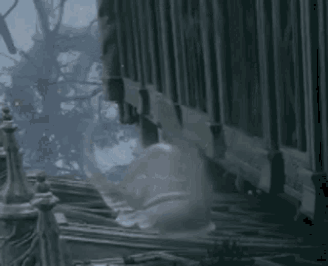 a bottle of soap is floating in the air in front of a fence in a forest .