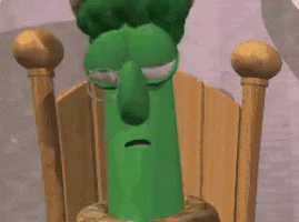 a green cartoon character wearing glasses is sitting in a chair