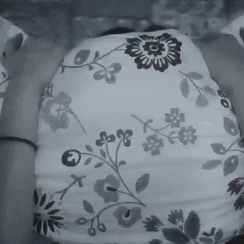a black and white photo of a person 's back with a floral pattern
