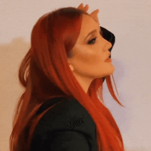 a woman with red hair is wearing a black jacket with dale stiles written on the sleeve