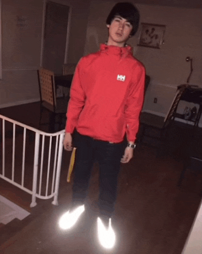 a man wearing a red jacket with the letter hh on the back